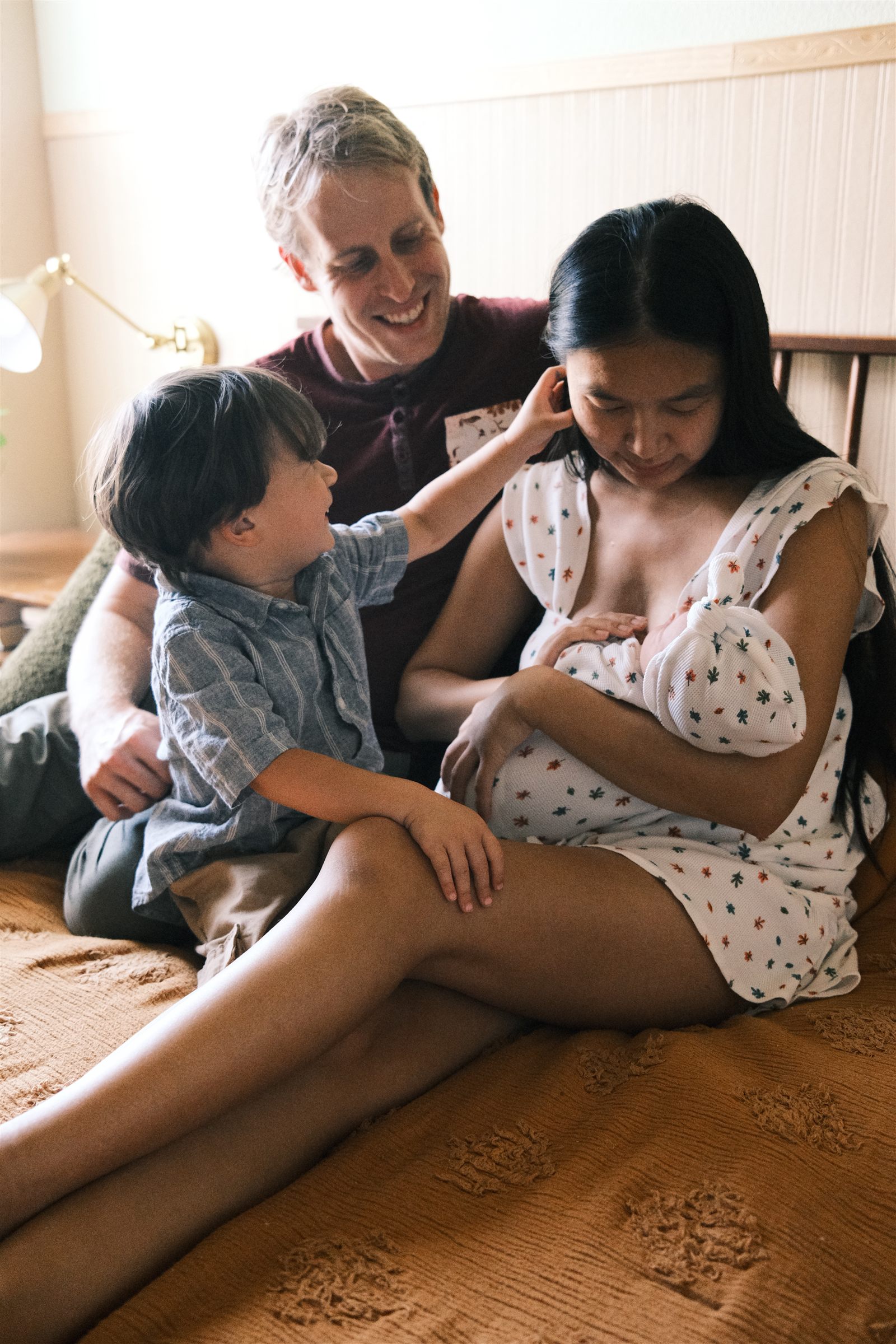 Family gathered on a bed with a baby in a matching handmade outfit